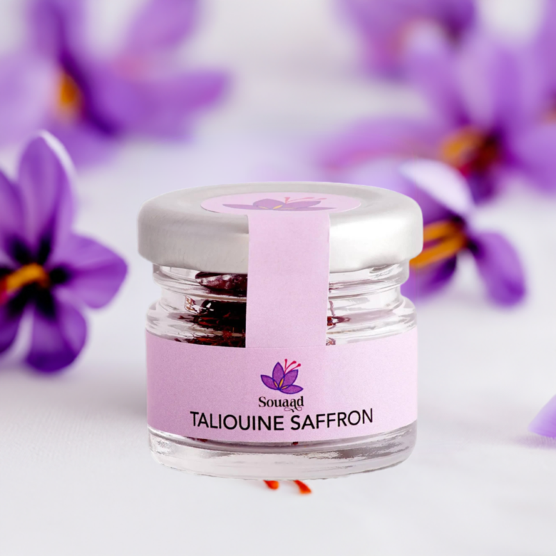 Glass jar containing 1g of Souaad's moroccan saffron set in front of crocus flowers highlighting the origin of the product